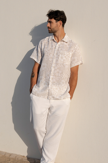 Homme portant une chemise et un pantalon blancs de la marque Off the Beach 