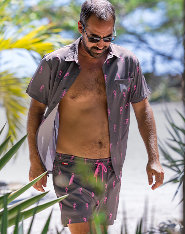 Man wearing a matching grey shirt and shorts set with a pink seahorse print from Hamabe. 