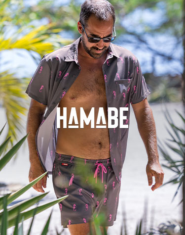 Man wearing a matching grey shirt and shorts set with a pink seahorse print from Hamabe. 