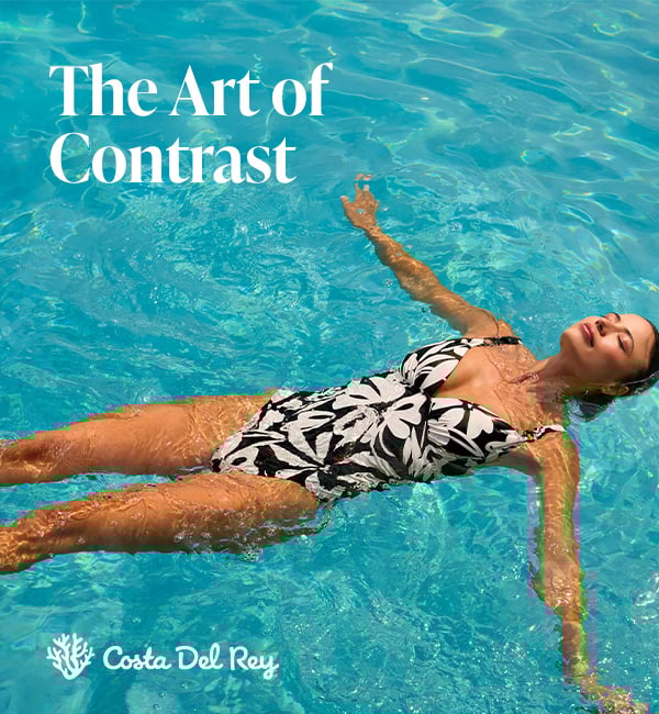 Woman wearing a black and white one-piece swimsuit from the brand Costa Del Rey.