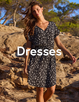 Woman in a black dress with white floral print, from Tropik.