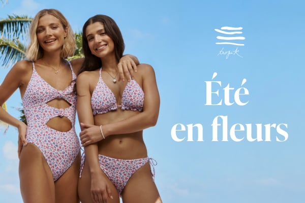 Femmes sous des palmiers portant des maillots de bain assortis fleuri rouge, bleu sur fond blanc de la marque Tropik.