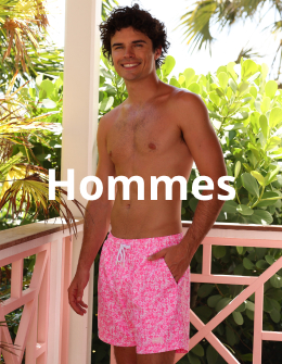 Homme sur un balcon portant un maillot fleuri rose et blanc de la marque Kulani Kinis.