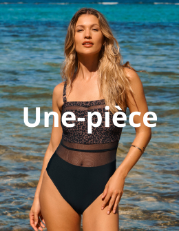 Femme se tenant devant l'eau et portant un maillot une-pi&egrave;ce au motif l&eacute;opard de la marque Turquoise Couture.