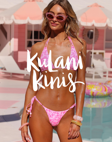 Woman in front of a pool wearing a pink and white floral bikini set from the brand Kulani Kinis.