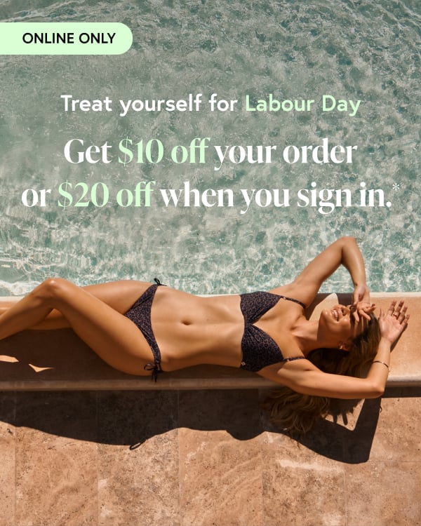 Woman relaxing while lying beside a pool, wearing a leopard-print bikini set from Turquoise Couture.
