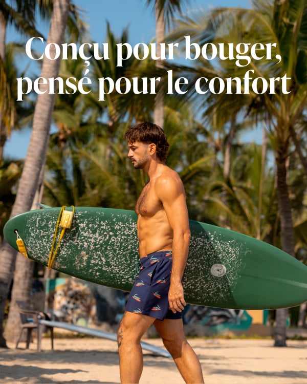 Homme marchant sur la plage en portant une planche de surf en portant un ensemble coordonn&eacute; d'un short et d'une camisole au motif de homards de la marque Hamabe.