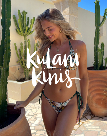 Woman walking among potted cacti, wearing a Kulani Kinis leopard-print bikini set.