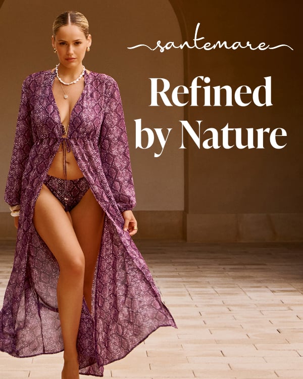 A woman walking through an architectural building, wearing a purple snakeskin-print bikini set and its matching kimono from the Santemare brand.