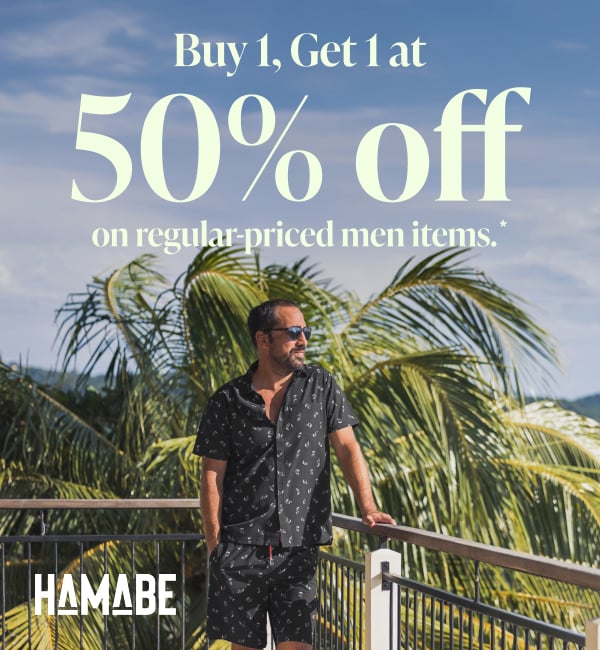 A man standing on a balcony railing and looking at the view while wearing a matching Hamabe outfit. 