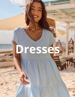 Woman on the beach wearing a short blue dress from the brand Off The Beach. 
