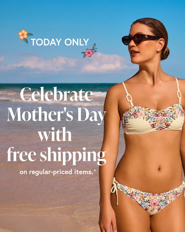 Woman on the beach gazing into the distance, wearing a floral bikini set from the Costa Del Rey brand.