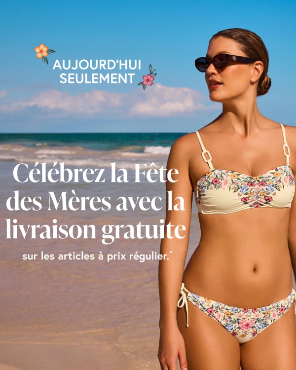 Femme sur la plage regardant au loin et portant un ensemble bikini fleuri de la marque Costa Del Rey.