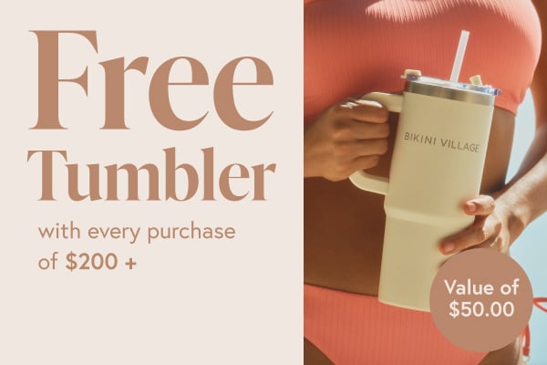 White Bikini Village tumbler held in hands.
