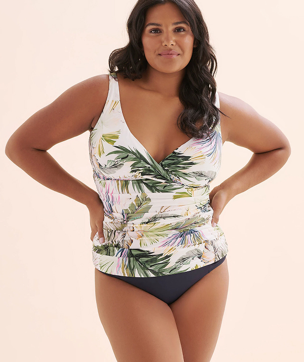 Woman wearing a leaf‑print tankini set by the brand Artesands.