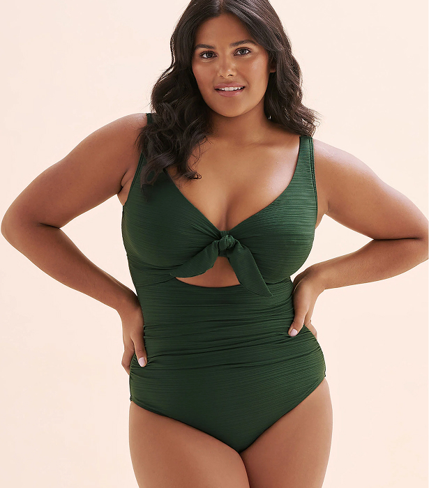 Woman wearing a green one‑piece swimsuit by the brand Artesands.