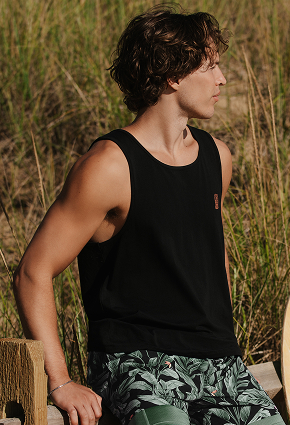 Man wearing a black tank top and swim short from the brand Hamabe. 