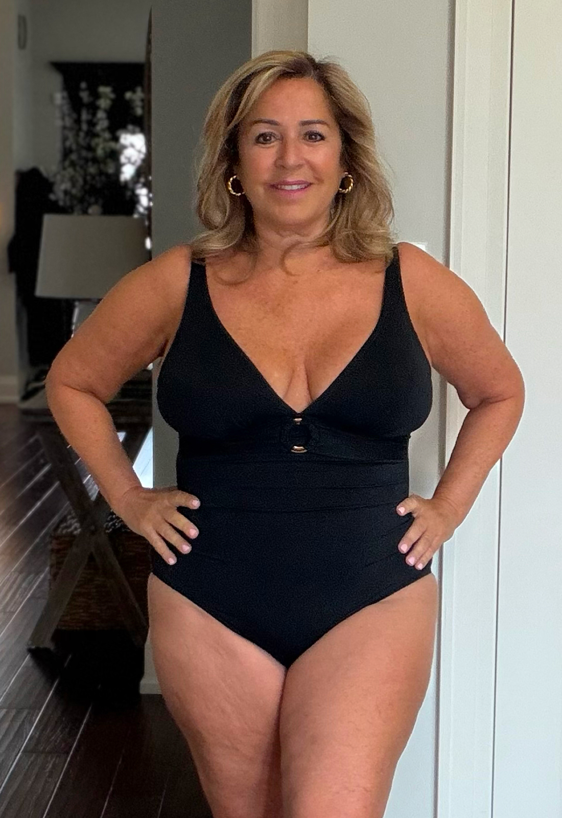 Anita wears the black plunge one-piece swimsuit from the Turquoise Couture brand.