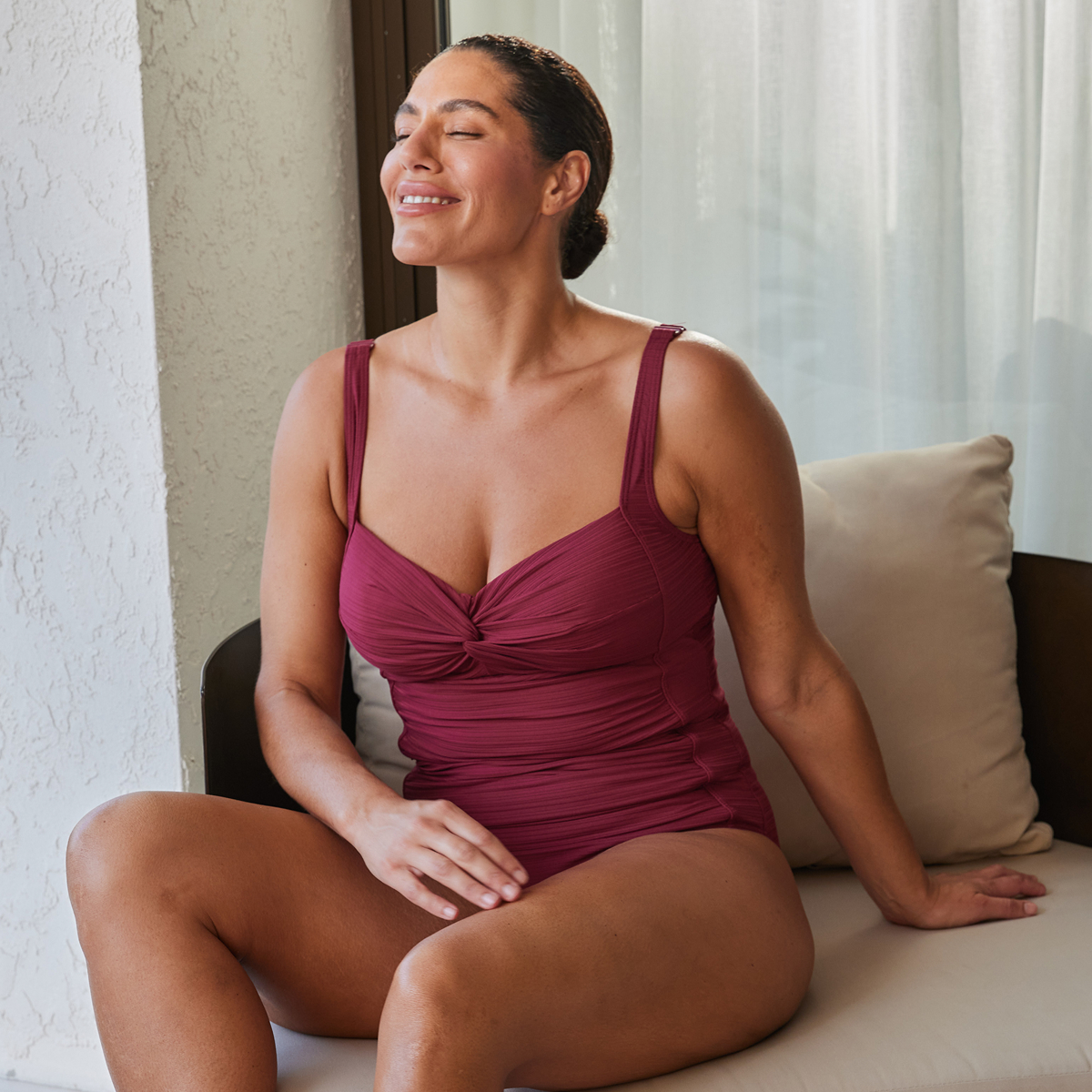 A woman wearing a burgundy one-piece swimsuit by Artesands – Bikini Village