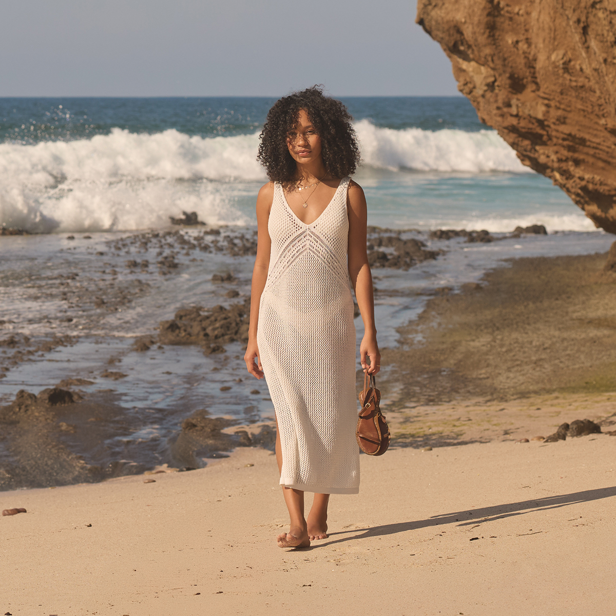 Woman wearing a white crochet dress from MyBikiniStory, walking on the beach - Bikini Village 