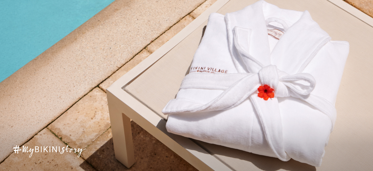 Folded robe on a lounge chair by a Bikini Village pool.