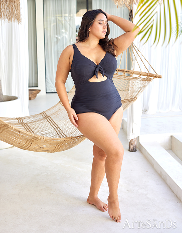 Femme devant un hamac portant un maillot une-pièce texturé noir de la marque Artesands.