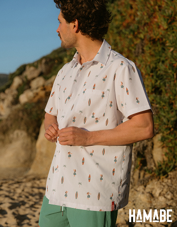 Homme portant une chemise avec motif de planche de surf et femmes hawaienne de la marque Hamabe.