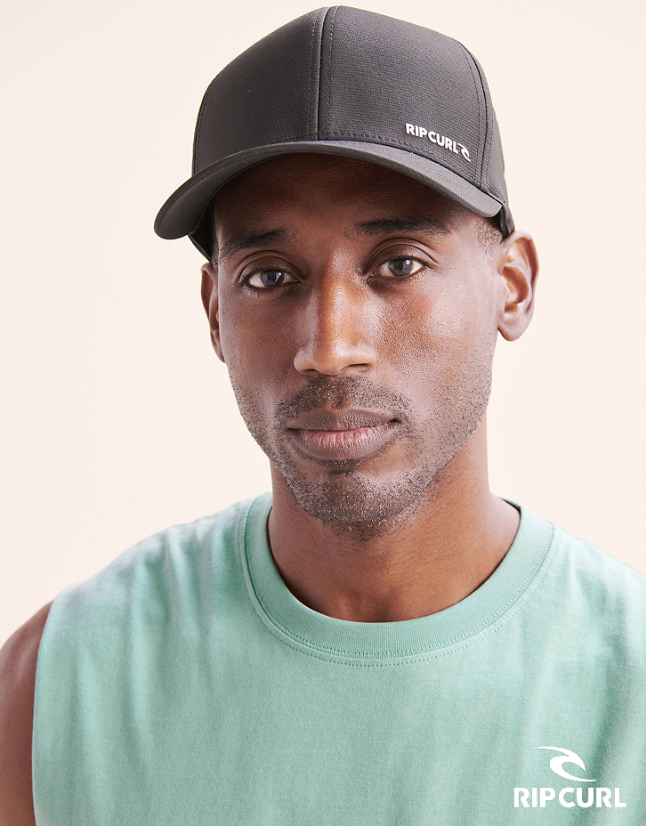 Homme portant une casquette grise de la marque Rip Curl.