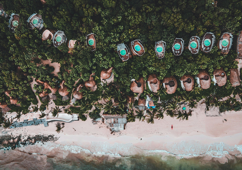 Mini-villas and beach in Tulum, Mexico. Photo by David Iglesias on Pexels.