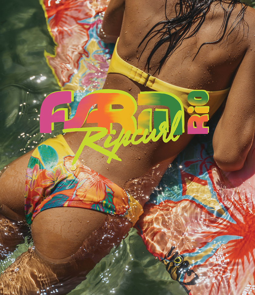 Woman on a surfboard wearing a tropical-print bikini set by Rip Curl x Farm Rio.