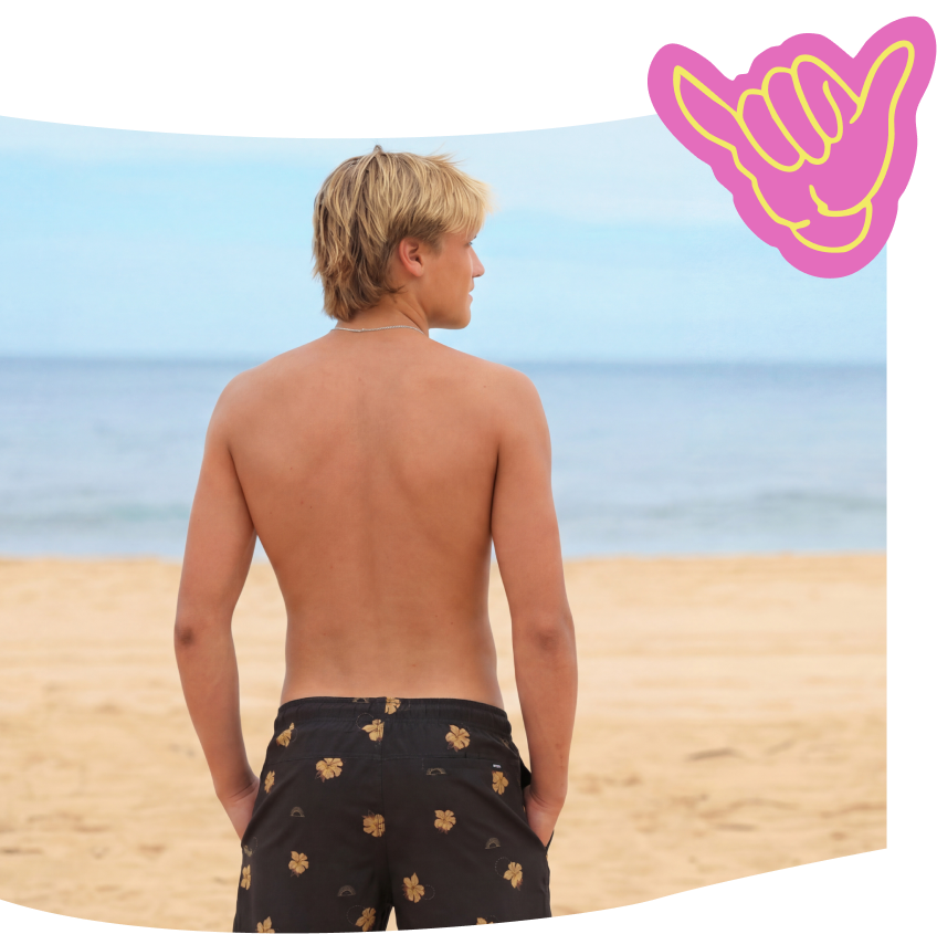 Man looking at the beach wearing a volley short from the brand Rip Curl